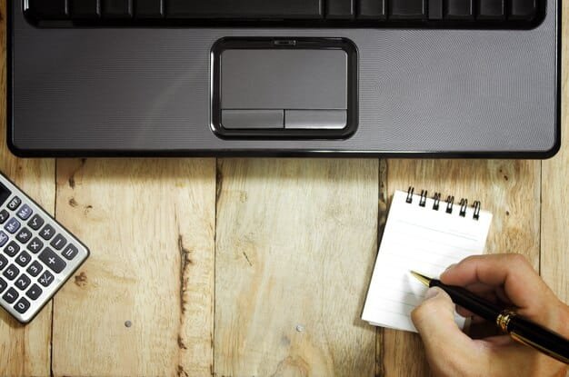 An overhead shot of a person's hands typing on a keyboard, with a calendar and a pen nearby. The focus is on the laptop screen displaying a credit score analysis tool.