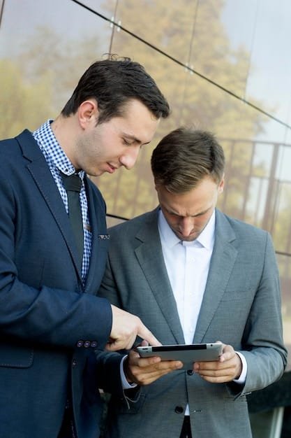 A person having a discussion with a financial advisor, reviewing investment options on a tablet. The scene suggests a professional consultation about managing investments during a career transition.